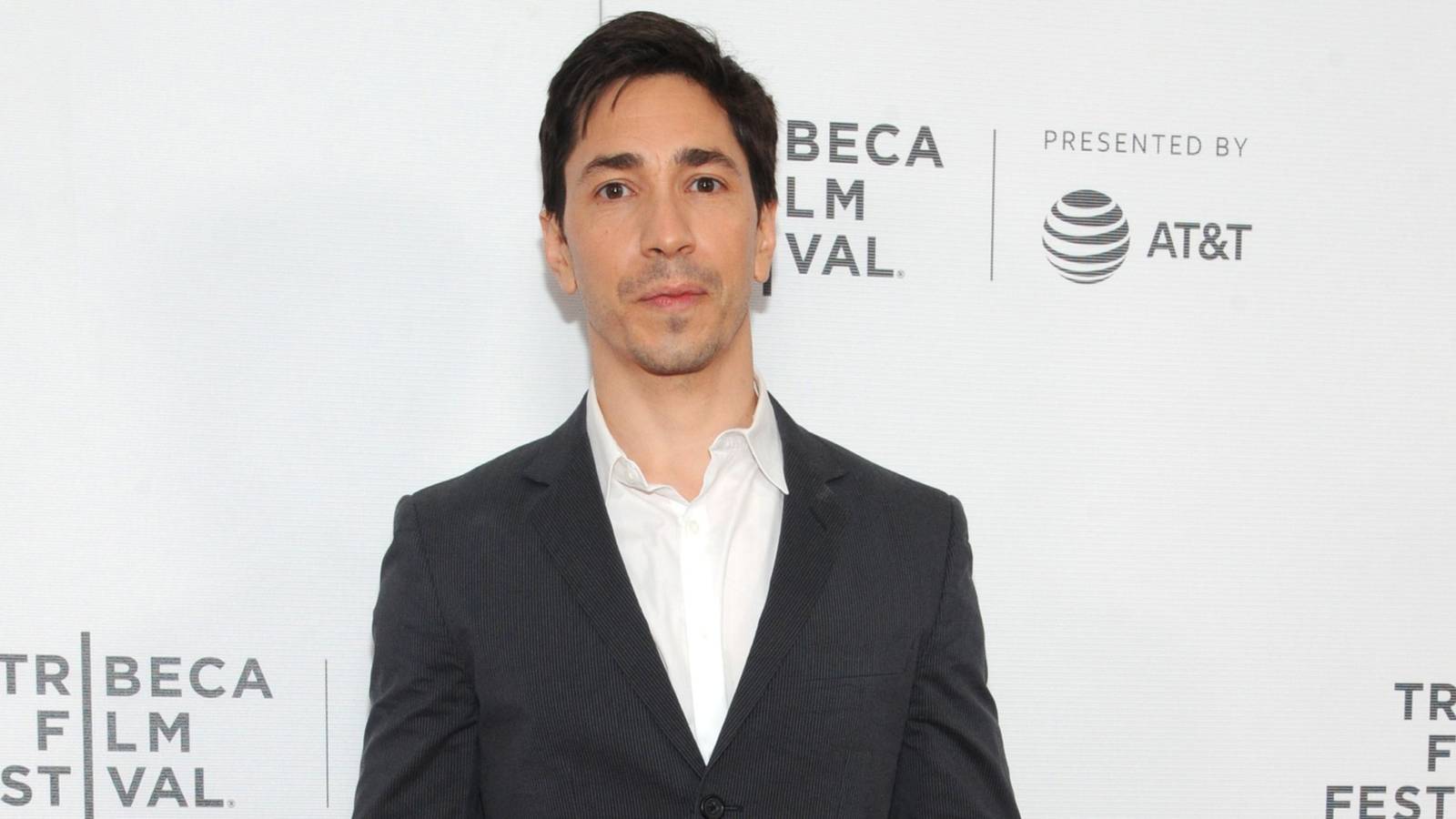 Justin Long en un evento de cine, con blazer oscuro sobre camisa blanca
