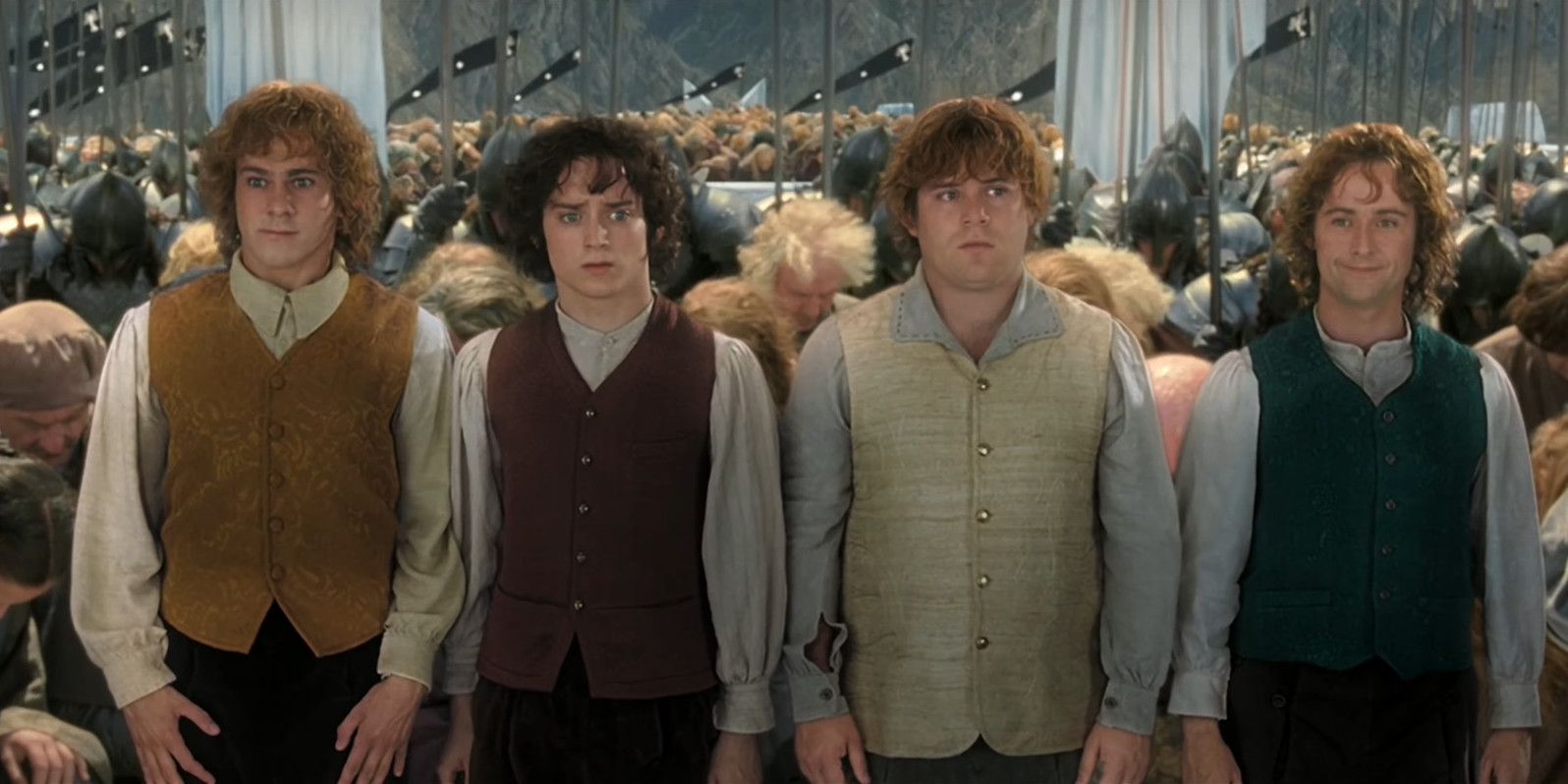 Frodo, Sam, Merry e Pippin surpresos durante a coroação em Minas Tirith